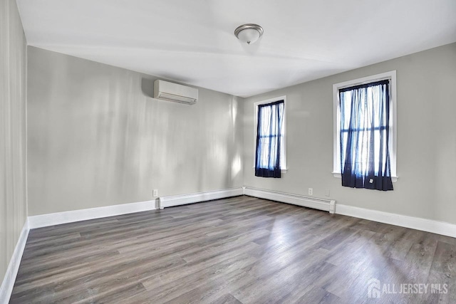 unfurnished room with an AC wall unit, a baseboard radiator, wood finished floors, and baseboards