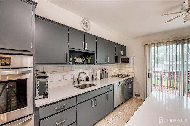 115 Broadway Ave, Colonia, NJ 07067 - kitchen featuring appliances with stainless steel finishes, a sink, a ceiling fan, backsplash, and light tile patterned flooring