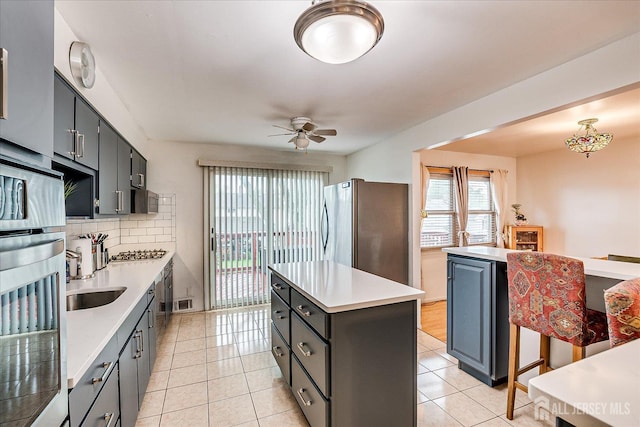 115 Broadway Ave, Colonia, NJ 07067 - kitchen with stainless steel appliances, a center island, ceiling fan, a sink, and light countertops