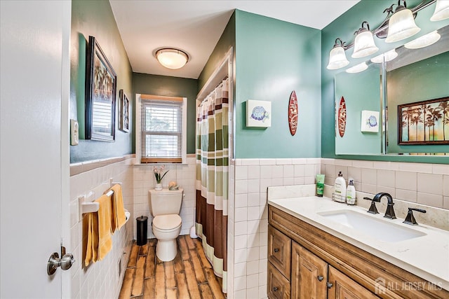 115 Broadway Ave, Colonia, NJ 07067 - bathroom featuring tile walls, vanity, toilet, wainscoting, and wood finished floors