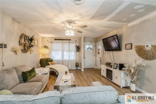 living room with ceiling fan and light hardwood / wood-style floors