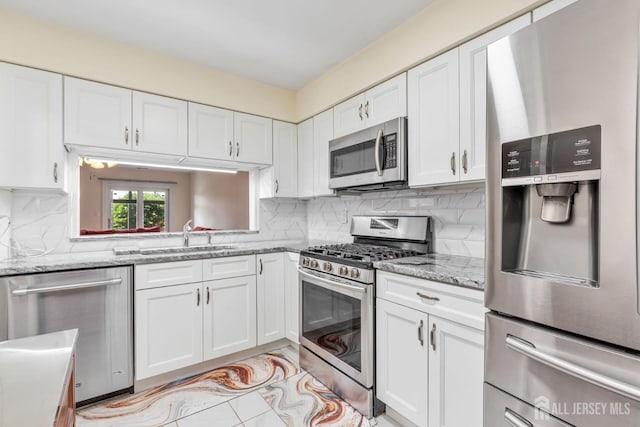 304 Woodbridge Commons Way, Iselin, NJ 08830 - kitchen featuring appliances with stainless steel finishes, white cabinets, backsplash, and light stone countertops