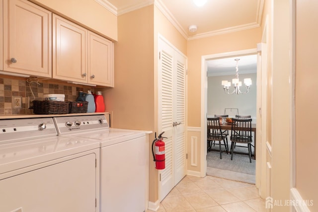 laundry area featuring cabinet space, independent washer and dryer, crown molding, a chandelier, and light tile patterned floors