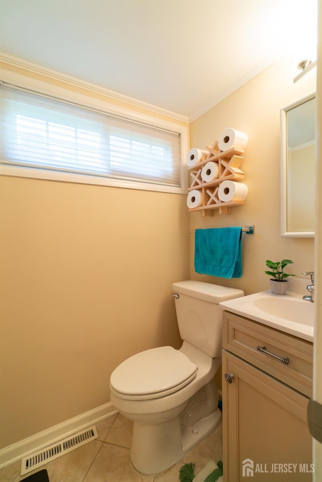bathroom featuring toilet, tile patterned floors, vanity, and ornamental molding