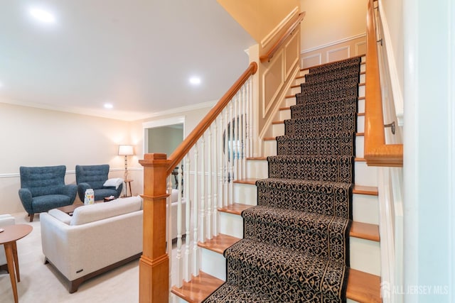 stairway featuring ornamental molding, recessed lighting, and a decorative wall