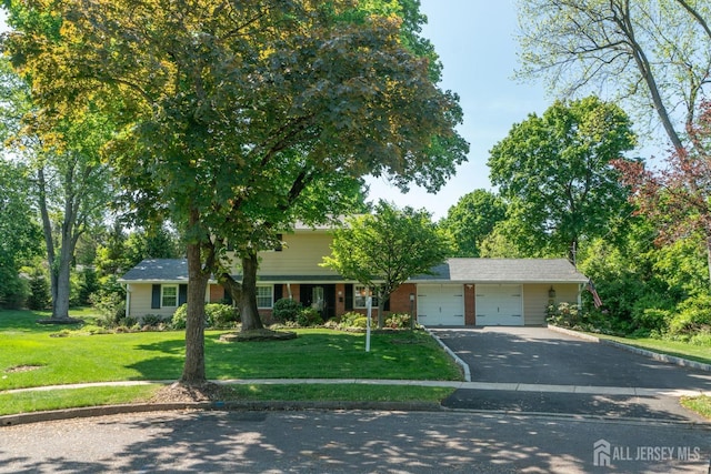 single story home with driveway, a garage, and a front yard