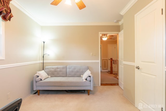 living area featuring a ceiling fan, crown molding, and carpet floors