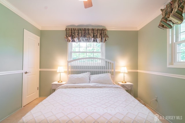 bedroom with crown molding, carpet, and a ceiling fan