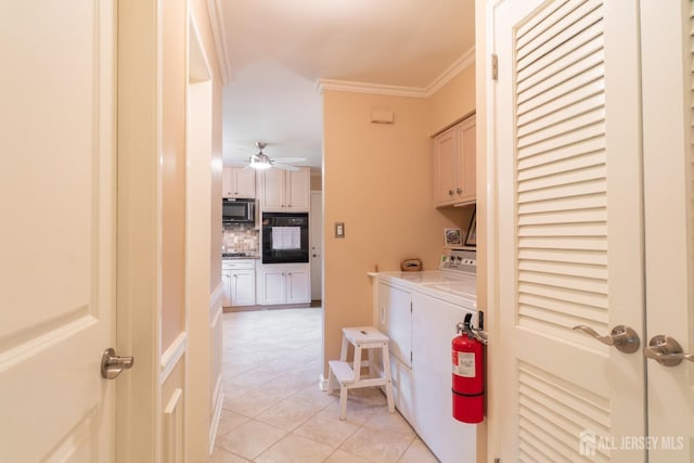 clothes washing area featuring cabinet space, washing machine and dryer, light tile patterned flooring, ornamental molding, and a ceiling fan