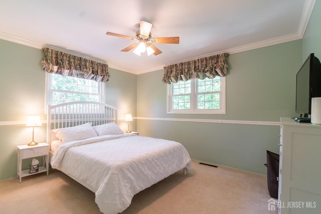carpeted bedroom with crown molding, ceiling fan, and baseboards