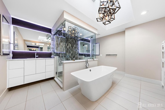 full bath featuring tile patterned floors, a shower stall, a freestanding bath, and vanity