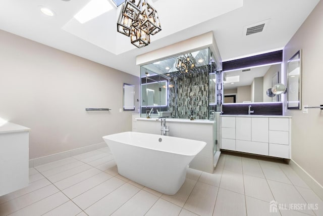 bathroom featuring tile patterned flooring, vanity, baseboards, a soaking tub, and a shower stall