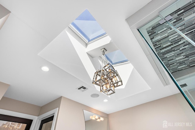 room details featuring recessed lighting, visible vents, and a notable chandelier