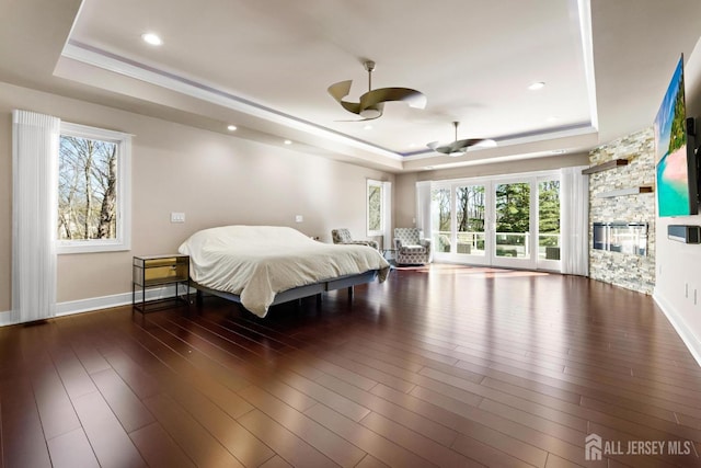 bedroom featuring baseboards, a tray ceiling, and dark wood finished floors