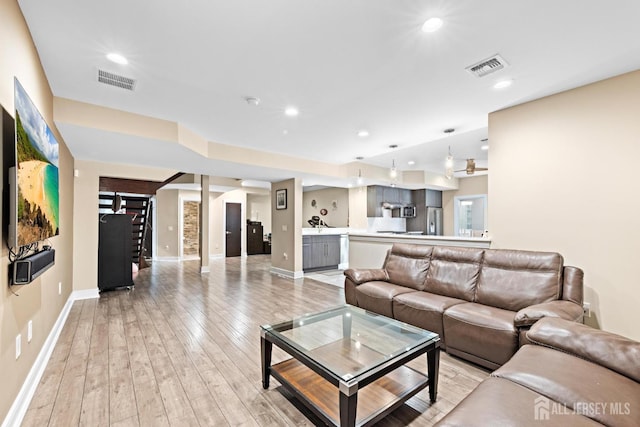 living room featuring stairway, recessed lighting, visible vents, and light wood-style floors