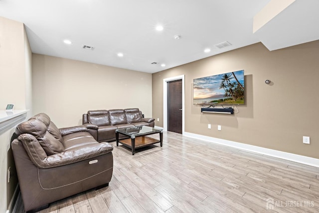 living room featuring light wood-type flooring, baseboards, visible vents, and recessed lighting