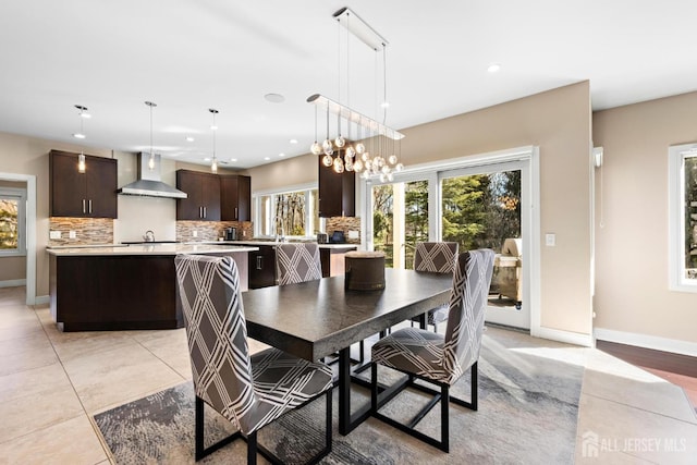 dining space featuring light tile patterned flooring, baseboards, a notable chandelier, and recessed lighting