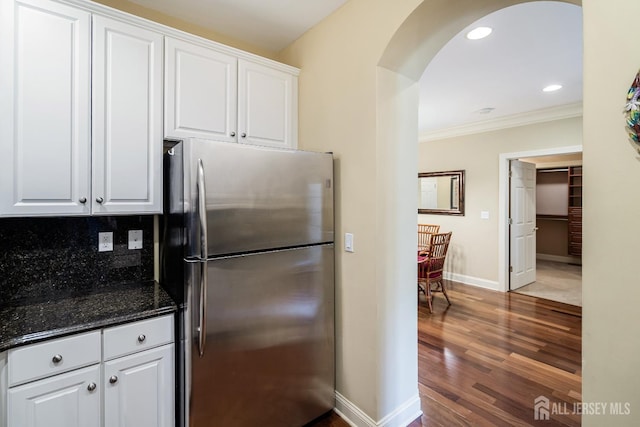 540 Cranbury Rd Unit 105, East Brunswick, NJ 08816 - kitchen featuring freestanding refrigerator, arched walkways, ornamental molding, white cabinets, and baseboards