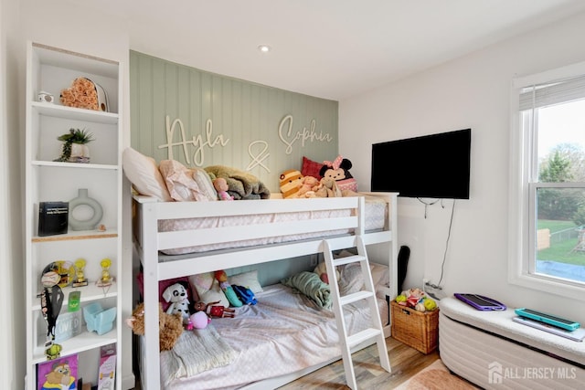 bedroom with multiple windows and wood finished floors