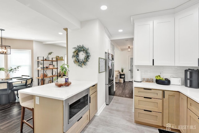 kitchen featuring a kitchen bar, light wood-type flooring, recessed lighting, and stainless steel appliances