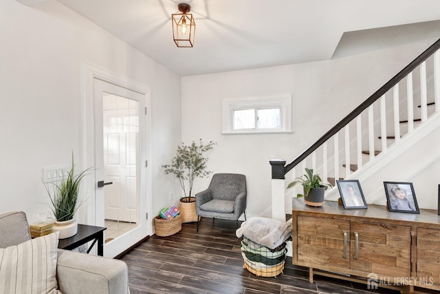 sitting room with wood finished floors, baseboards, and stairway