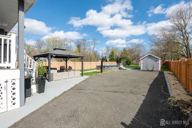 exterior space featuring a gazebo, a trampoline, an outdoor structure, a patio, and a storage unit