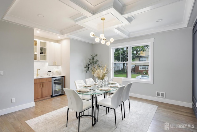 14 Thomasine St, Edison, NJ 08817 - dining room featuring beverage cooler, wet bar, coffered ceiling, light wood finished floors, and a chandelier