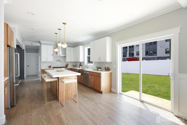 14 Thomasine St, Edison, NJ 08817 - kitchen with appliances with stainless steel finishes, light wood finished floors, a breakfast bar area, tasteful backsplash, and light countertops