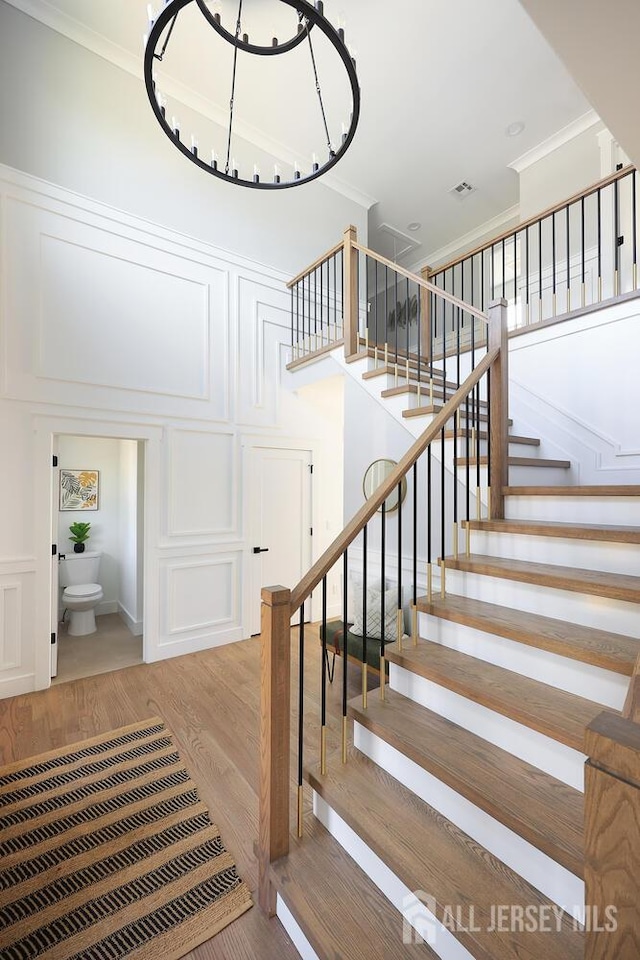 14 Thomasine St, Edison, NJ 08817 - stairs with crown molding, wood finished floors, a decorative wall, and a chandelier