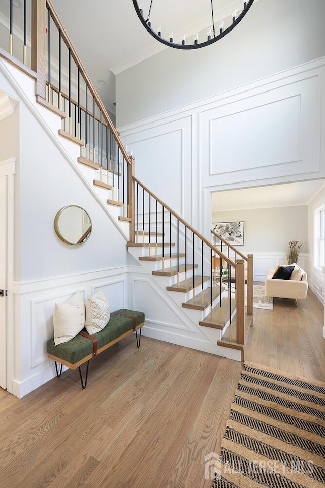 14 Thomasine St, Edison, NJ 08817 - stairs with a decorative wall, wood finished floors, crown molding, and a wainscoted wall