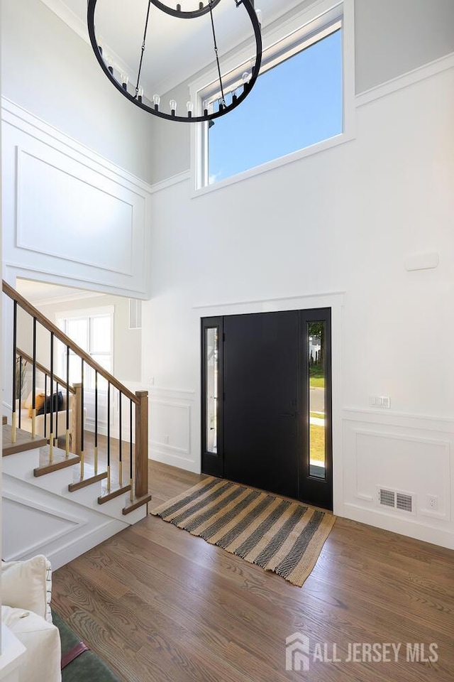 14 Thomasine St, Edison, NJ 08817 - entrance foyer with a high ceiling, wood finished floors, stairway, a decorative wall, and a chandelier