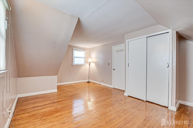 bonus room featuring lofted ceiling and light hardwood / wood-style floors