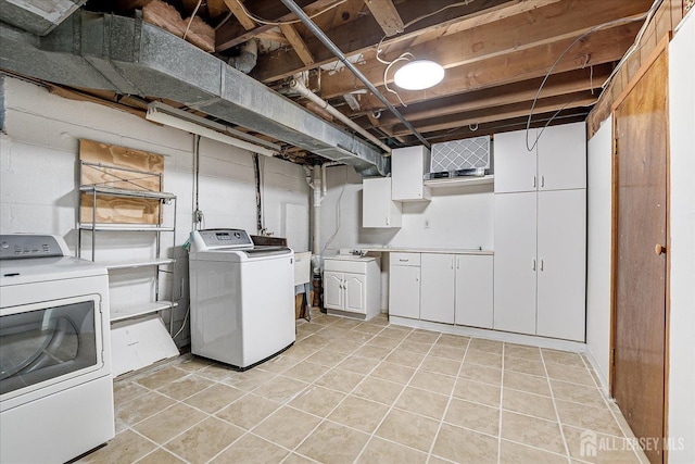 clothes washing area with cabinets, washing machine and dryer, and light tile patterned floors