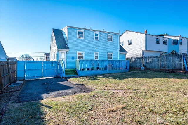 rear view of house with a yard and a deck