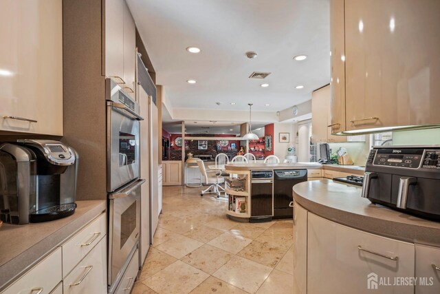 kitchen with pendant lighting, black dishwasher, double oven, and kitchen peninsula