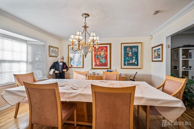 dining area featuring light hardwood / wood-style floors, crown molding, and a chandelier