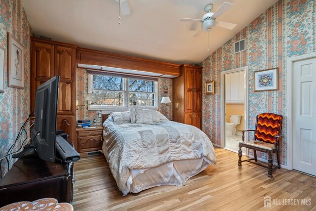 bedroom featuring ceiling fan, lofted ceiling, light hardwood / wood-style flooring, and ensuite bath