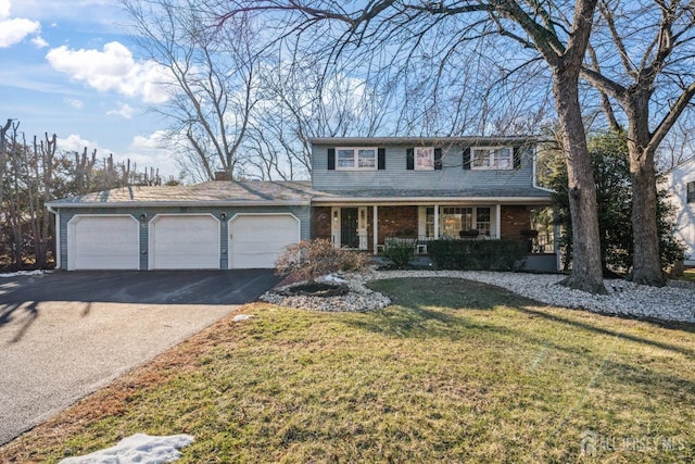 view of front of home with a garage, a front yard, and a porch