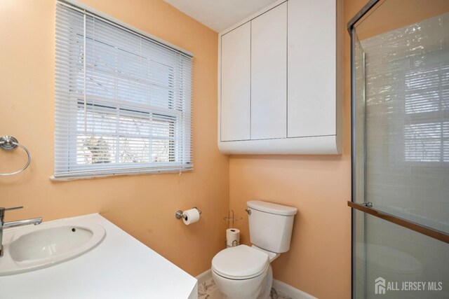 bathroom featuring sink, toilet, and an enclosed shower