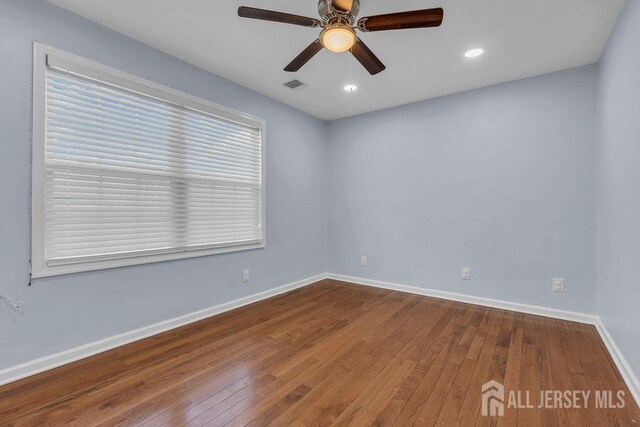 empty room with hardwood / wood-style floors and ceiling fan