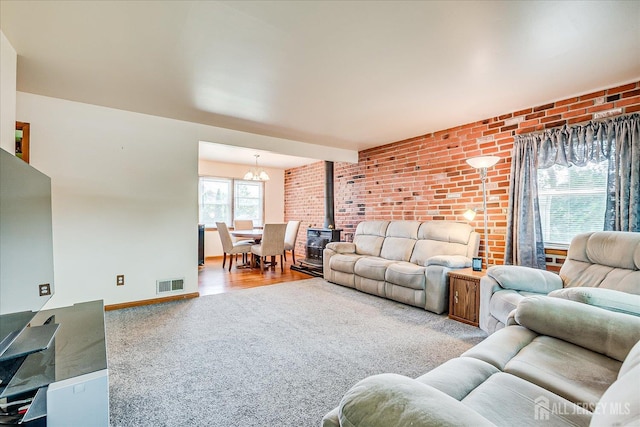 108 Smith St, South Plainfield, NJ 07080 - carpeted living area with a wood stove, a chandelier, and brick wall