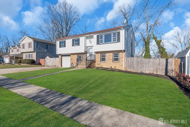 raised ranch featuring a garage and a front yard