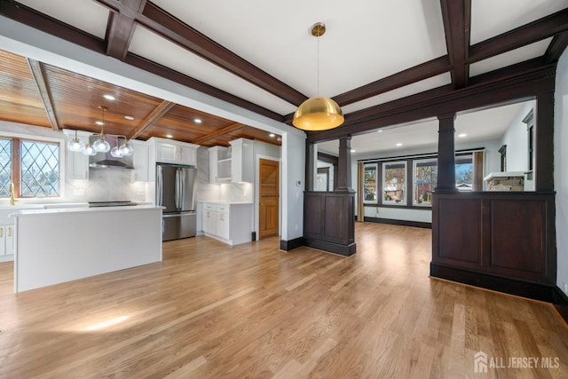 657 Amboy Ave, Edison, NJ 08837 - kitchen featuring stainless steel fridge, ornate columns, white cabinets, healthy amount of natural light, and beamed ceiling