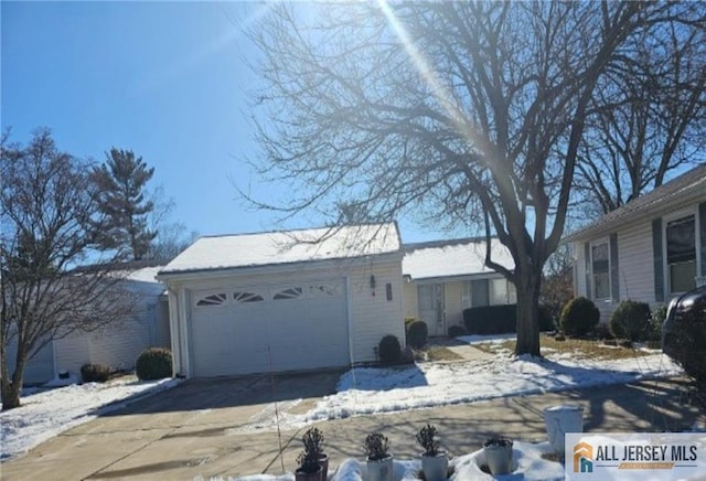 snow covered property with a garage