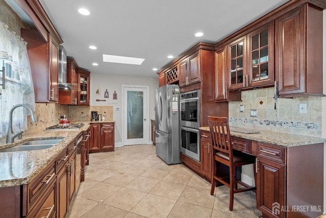 kitchen with light tile patterned floors, a skylight, a sink, appliances with stainless steel finishes, and glass insert cabinets