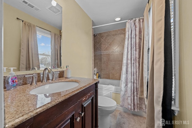 bathroom featuring toilet, visible vents, shower / bath combo with shower curtain, and vanity