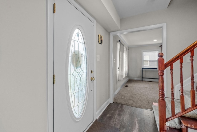 entryway with stairs, baseboards, and wood finished floors