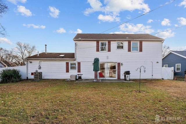 rear view of property featuring a patio, central AC unit, a lawn, and fence