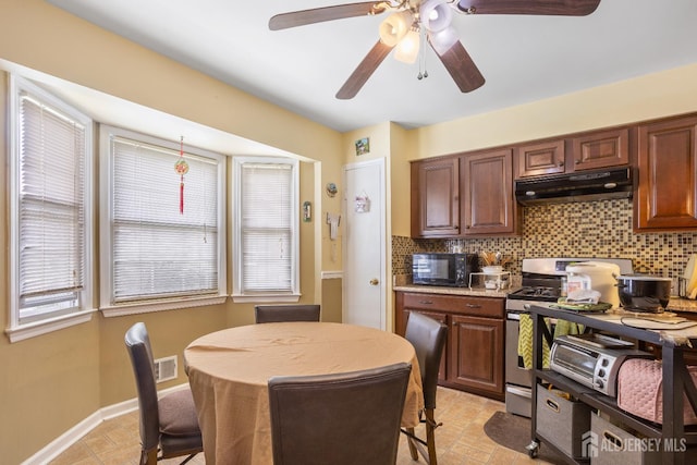 32 Astor Ct, Sayreville, NJ 08872 - kitchen with under cabinet range hood, stainless steel gas range, backsplash, and black microwave