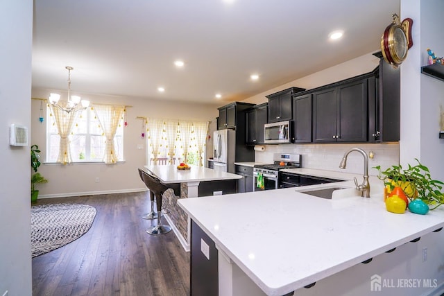102 Matutina Rd, Monroe, NJ 08831 - kitchen featuring appliances with stainless steel finishes, light countertops, tasteful backsplash, dark wood-style flooring, and a kitchen island